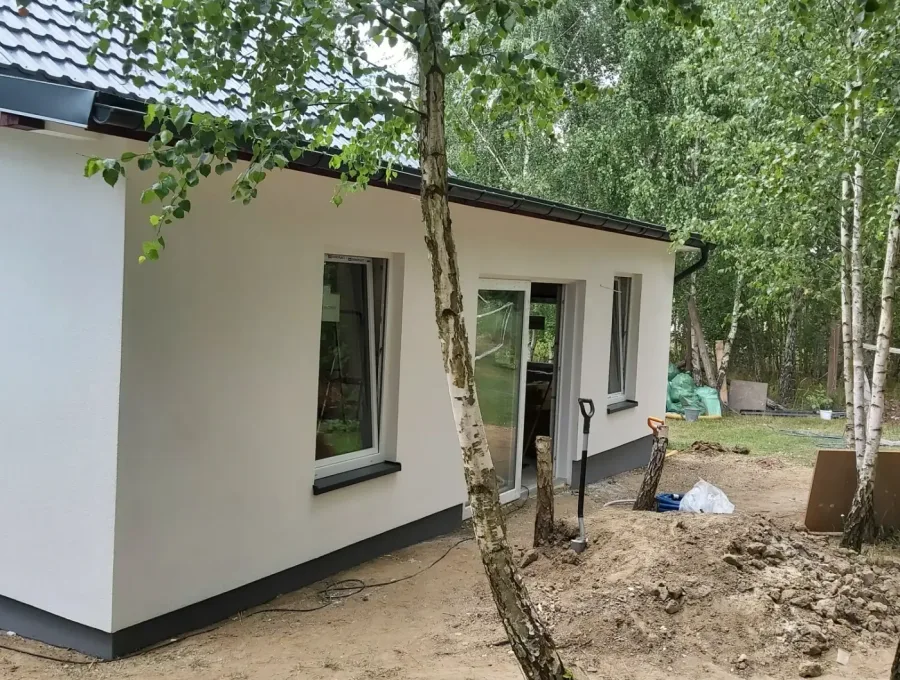 Biała elewacja domu wśród zieleni